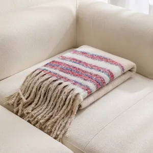 Detalle de manta de punto bouclé grueso con rayas de colores y flecos