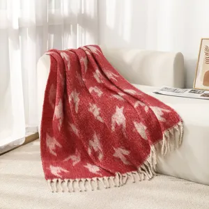 Detalle de manta de imitación de mohair pata de gallo roja con flecos suaves y textura.