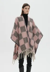 Vue en pied d'un modèle portant un châle en mohair à carreaux rose et gris avec glands