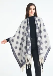 Vista detallada de un chal poncho de mezcla de mohair a lunares con elegantes flecos