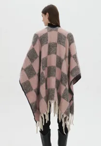 Vue détaillée d'un poncho en mohair à carreaux rose et gris avec des franges stylées.