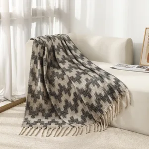Cozy faux mohair throw blanket with ethnic zigzag pattern and tassels on sofa.
