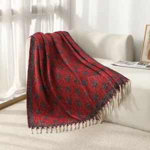 Gros plan d'une couverture en jacquard rouge à pois doux avec des franges blanches