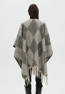 Vista posteriore dettagliata di un pesante poncho grigio a rombi con nappe decorative