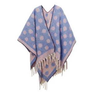 Detalle de un poncho de mohair grueso con lunares y suaves borlas decorativas en el borde