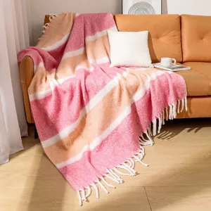 Detalle de manta gruesa a rayas de imitación mohair con borlas decorativas en el sofá
