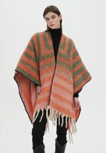 Detailed look at striped boucle yarn poncho featuring white fringe and soft faux mohair