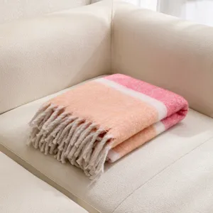 Primer plano de manta de felpa gruesa tipo mohair con suaves rayas rosas y naranjas