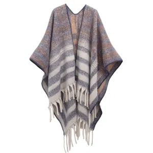 Thick striped boucle yarn poncho with long fringes for autumn and winter.