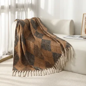 Vue détaillée d'une couverture douce à losanges en imitation mohair avec pompons élégants