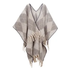 Dettaglio dello scialle in maglia a rombi invernale con texture morbida e nappe