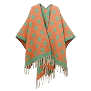 Vista detallada del poncho de mohair jacquard con lunares naranja y verde y flecos