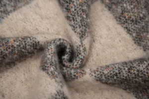 Détail du tissu bouclé en faux mohair avec jacquard à carreaux et mouchetures.