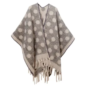 Vista de detalle de un poncho de mohair gris a lunares con costuras moradas y flecos