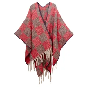 Détail d'un châle en mohair à carreaux rouges et gris avec des franges blanches douces