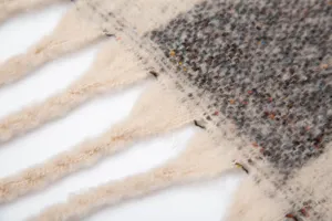 Détail d'une écharpe en imitation mohair montrant des franges épaisses et un motif losange