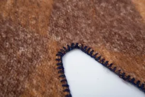 Dettaglio ravvicinato di scialle in finto mohair bouclé con bordo a punto coperta.