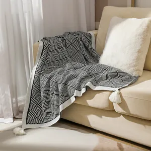 Close-up of bohemian black and white geometric knitted blanket texture with white tassels