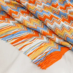 Vista detallada de manta de punto bohemia con patrón de zigzag colorido y flecos