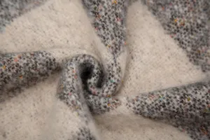 Gros plan d'un châle épais en jacquard de mohair à carreaux et texture mouchetée.