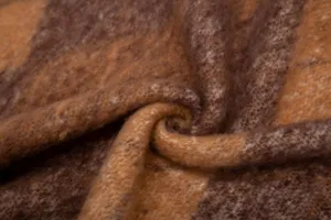 Vista macro dettagliata di una morbida sciarpa in finto mohair bouclé con motivo a quadri