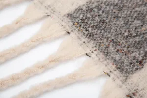 Gros plan d'un châle en jacquard de mohair épais montrant la texture et les glands