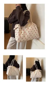 Borsa da viaggio grande con stampa a fragole mostrata su modella in ambiente interno