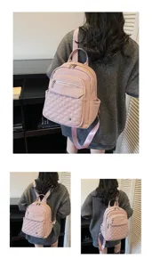 Back view of a woman wearing a stylish pink quilted soft leather backpack for travel