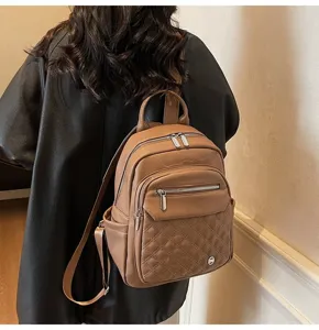 Detail shot of a brown soft leather backpack with quilted pattern for women's travel.