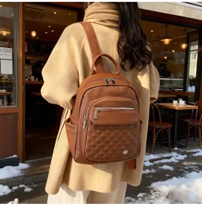 Stylish brown soft leather backpack for women shown worn in a cozy outdoor cafe setting