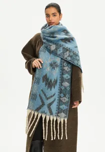 Detailed view of a blue ethnic jacquard scarf with decorative tassels and mohair feel.