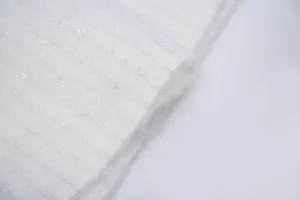 Dettaglio macro della sciarpa bianca in finto mohair con fili metallici argentati