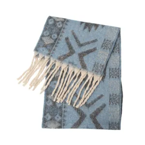 Detailed view of the ethnic jacquard pattern and soft tassels on the light blue scarf