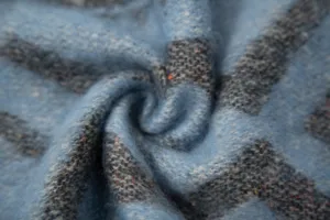 Close-up of soft faux mohair scarf with blue ethnic jacquard pattern and texture