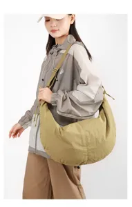 Large khaki nylon crescent hobo bag for women being worn by a model in casual gear