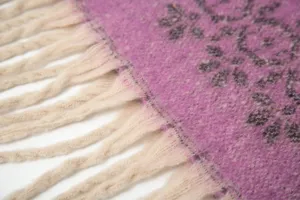 Nahaufnahme der Makro-Textur des lila Schneeflocken-Mohair-Schals mit Quasten