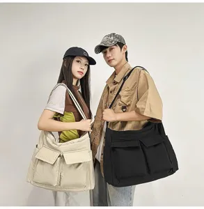 Two models wearing vintage oversized canvas messenger bags in beige and black colors