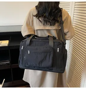 Black large capacity travel duffel bag carried by model in casual lifestyle setting
