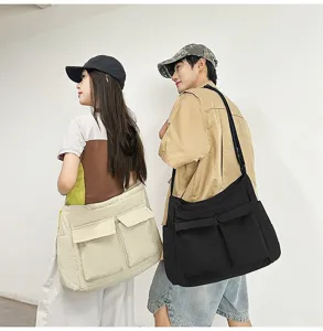 Macro view of oversized vintage canvas messenger bags in black and beige on models