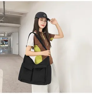 A large black canvas messenger bag shown on model with dual front pockets detail view