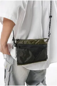 Detail of army green nylon messenger bag with mesh front pocket worn by a model