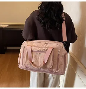 Close-up of a large pink multi-functional travel bag worn by a model for trips and gym