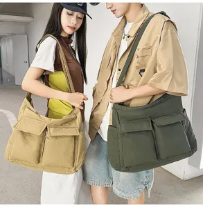 A couple wearing large vintage canvas messenger bags in khaki and olive green.