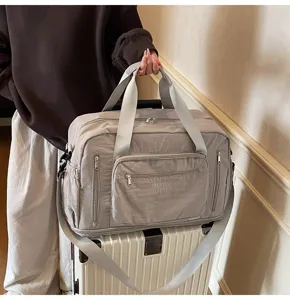 Large capacity expandable travel bag with multiple pockets shown on top of a suitcase