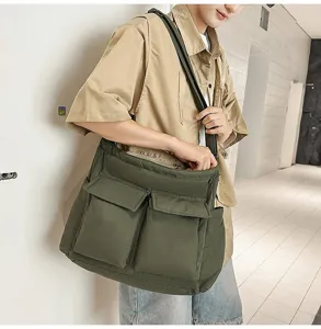 Detail view of large olive green padded crossbody bag worn by model for casual street style