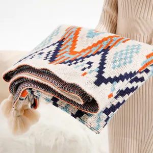 Bohemian knitted throw blanket with ethnic patterns and tassels for sofa or travel.