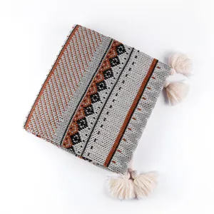 Detailed view of Bohemian knitted throw blanket with ethnic patterns and decorative tassels.