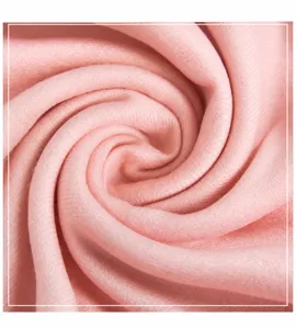 Close-up macro detail of soft pink wool blend fabric texture with elegant spiral folds