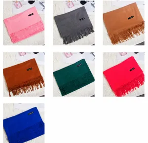 Collection of various colored soft scarves with fringe tassels in pink, grey, camel and blue