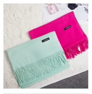 Close-up of mint green and fuchsia solid color scarves with elegant tassel details